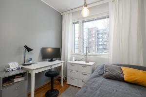 - une chambre avec un lit et un bureau avec un ordinateur dans l'établissement Kokonainen huoneisto 73m2 keskeisellä sijainnilla, ilmainen parkkipaikka, à Lahti