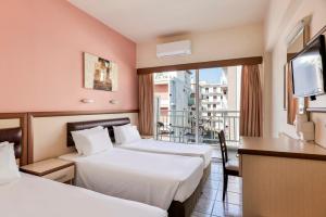 Ένα ή περισσότερα κρεβάτια σε δωμάτιο στο Pearl Hotel