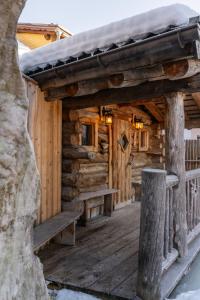 eine Hütte mit einer Holzterrasse mit Bänken darauf in der Unterkunft Wander- und Wellnesshotel Kanzler in Bad Mitterndorf