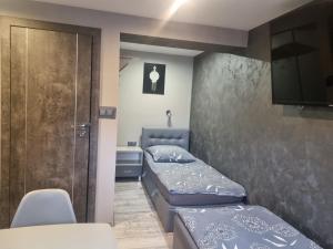 a small room with two beds and a television at Przystań in Rozalin