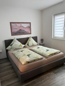 een slaapkamer met een bed met 2 kussens erop bij FeWo Perle Amaya in Sassenburg