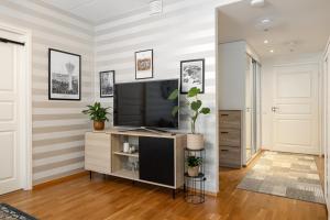 ラハティにあるKokonainen huoneisto 73m2 keskeisellä sijainnilla, ilmainen parkkipaikkaのリビングルーム(エンターテイメントセンター内の薄型テレビ付)