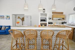 une cuisine avec trois tabourets de bar à un comptoir dans l'établissement Rodrigues Holiday Family Villa Zourit, à Rodrigues Island