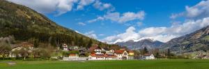 a group of houses in a green field with mountains at Penker Wirt Zimmer BANK in Penk