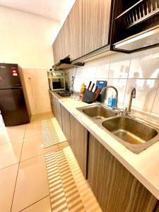 a small kitchen with a sink and a refrigerator at Casa Budi Dwiputra 15 Putrajaya in Putrajaya