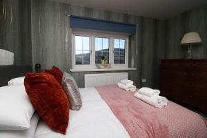 Risca的住宿－Peaceful Haven: Nature, Luxury, Wellbeing & Cuisine，一间卧室配有一张大床和毛巾
