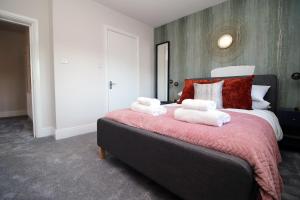 a bedroom with a large bed with towels on it at Peaceful Haven: Nature, Luxury, Wellbeing & Cuisine in Risca