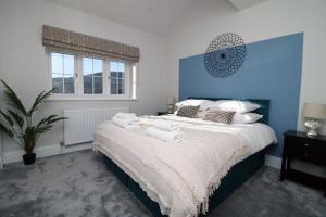 a bedroom with a large bed with towels on it at Peaceful Haven: Nature, Luxury, Wellbeing & Cuisine in Risca