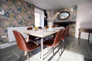 a dining room with a table and chairs and a mirror at Peaceful Haven: Nature, Luxury, Wellbeing & Cuisine in Risca