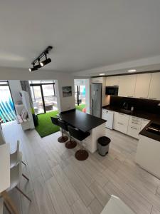 a large kitchen with a black table in a room at Secret Surf House. Casa de playa. in Playa del Hombre