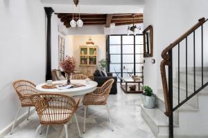 sala de estar con mesa y sillas en Magno Apartments Vírgenes Luxury House en Sevilla