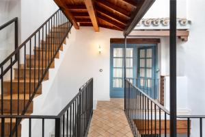 einen Flur mit Treppe und blauer Tür in der Unterkunft Magno Apartments Vírgenes Luxury House in Sevilla