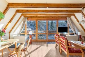 a dining room with a table and chairs and a large window at Ferienhaus Moritz in Siegsdorf