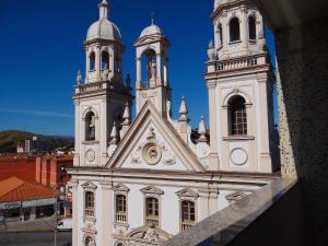 una iglesia blanca con dos torres en un edificio en Kafé Hotel en Guaratinguetá