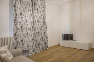 - un salon avec un canapé et une télévision dans l'établissement La Casa dei Racconti, à Castelraimondo