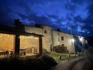 a building with lights on the side of it at night at Domaine La Tour in Loubens