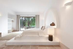 una camera bianca con letto e lampada di Finca La Familia Naranja a Coín