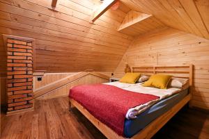 a bedroom with a bed in a wooden cabin at Poza Horyzont in Korbielów