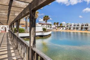a bridge over the water at a resort at Home2Book Sunny Apt Pool & Beach, Costa Teguise in Costa Teguise