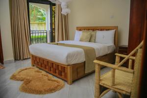 a bedroom with a large bed and a balcony at Fort Suites in Fort Portal