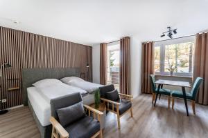 a bedroom with a bed and a table and chairs at Juri5 in Baiersbronn mit Pool in Baiersbronn
