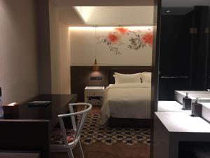 um quarto com uma cama e uma secretária com uma cadeira em Paco Hotel Dongpu Guanghzou -Free Shuttle Bus for Canton Fair em Guangzhou