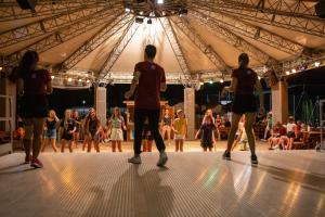 a group of people dancing on a dance floor in a tent at Estivo Premium Deluxe mobile homes on Camping Del Sole Village in Iseo +68 photos