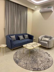 ein Wohnzimmer mit einem blauen Sofa und einem Tisch in der Unterkunft عمارة المهدية in Riad