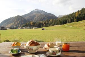 una mesa de madera con tazones de comida y vistas a un campo en Das Ferienhaus in Achenkirch en Achenkirch
