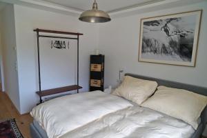 Un dormitorio con una cama blanca con una foto en la pared en Das Ferienhaus in Achenkirch en Achenkirch
