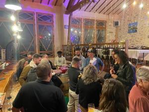 a group of people standing around a bar in a room at Domaine La Tour in Loubens