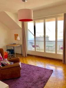 een woonkamer met een bank en een paars tapijt bij Ganze Wohnung mit Balkon,schöne Aussicht,Küche,Bad,Wifi in Bazel