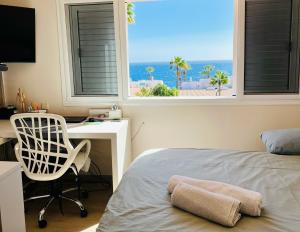 ein Schlafzimmer mit Bett, Schreibtisch und Fenster in der Unterkunft Villa with sea view and luxury heated pool in San Miguel de Abona + 63 Fotos