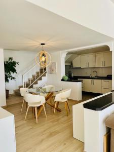 eine Küche und ein Wohnzimmer mit einem Glastisch und Stühlen in der Unterkunft Villa with sea view and luxury heated pool in San Miguel de Abona
