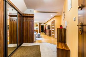 um corredor que dá acesso a uma sala de estar com paredes de madeira em Przy Nosalu 42 Apartments SPA&SKI Jacuzzi Sauna Free em Zakopane