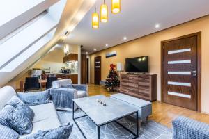 a living room with a couch and a christmas tree at Przy Nosalu 42 Apartments SPA&SKI Jacuzzi Sauna Free in Zakopane