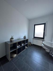 a bathroom with a sink and a toilet and a window at Ferienwohnung Eira in Bonerath