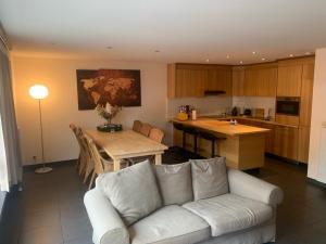 a living room with a couch and a table and a kitchen at Casa Alness in Wetteren
