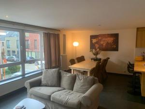 a living room with a couch and a table at Casa Alness in Wetteren +2 photos