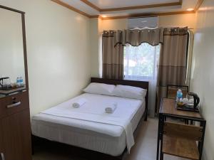 - une petite chambre avec un lit et une fenêtre dans l'établissement ZL TRAVELERS INN, à Batuan