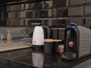 una macchinetta del caffè seduta su un bancone in cucina di Amazing Garden apartment a Tel Aviv