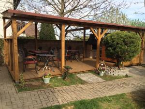 a wooden gazebo with a table and chairs at Restaurace-Penzion U Pilota in Kněževes