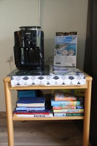 einen Tisch mit einer Kaffeemaschine und einem Stapel Bücher in der Unterkunft Family Apartment MiniGlück in Sankt Englmar