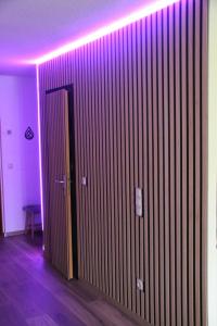Zimmer mit einer lila Wand und einer Tür in der Unterkunft Family Apartment MiniGlück in Sankt Englmar