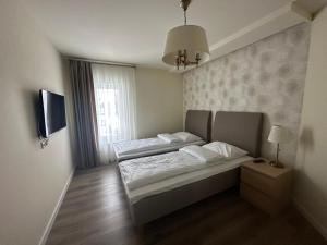 een slaapkamer met 2 bedden en een raam bij Apartamentai in Marijampolė