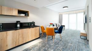施柯拉爾斯卡波倫巴的住宿－Apartamenty Sun & Snow Złoty Horyzont，客房设有厨房、桌子和椅子。
