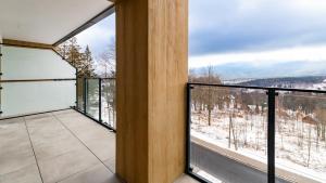 a balcony with a view of the snow covered mountains at Złoty Horyzont, Sun & Snow in Szklarska Poręba