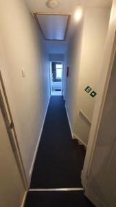 a hallway leading to a room with a long hallway at Contractors-City Centre-Parking-Sleeps 9 -Smart TV, 2 Toilets! in Coventry