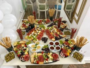 una mesa llena de diferentes tipos de alimentos en Hotel Restaurant Casa Cu Tei Craiova en Craiova