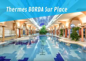 Cette chambre offre une vue sur la piscine d'un bâtiment avec les mots « border baroda ». dans l'établissement Borda -41- au coeur des Thermes Borda, à Dax